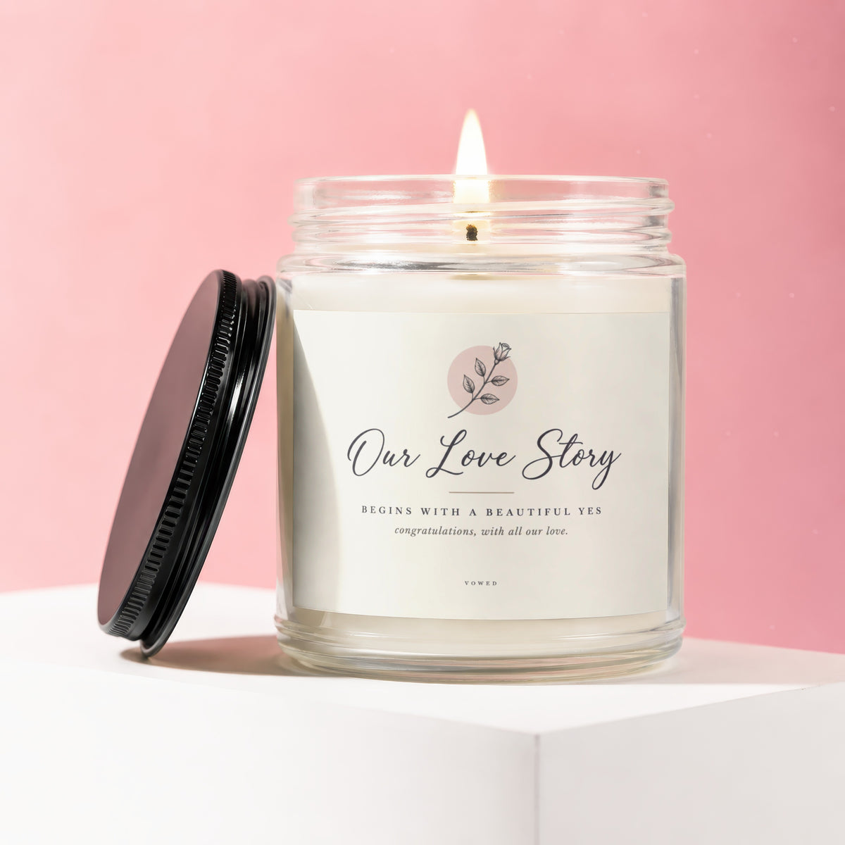 Lit candle in a glass jar with lid off, text reads "Our Love Story"