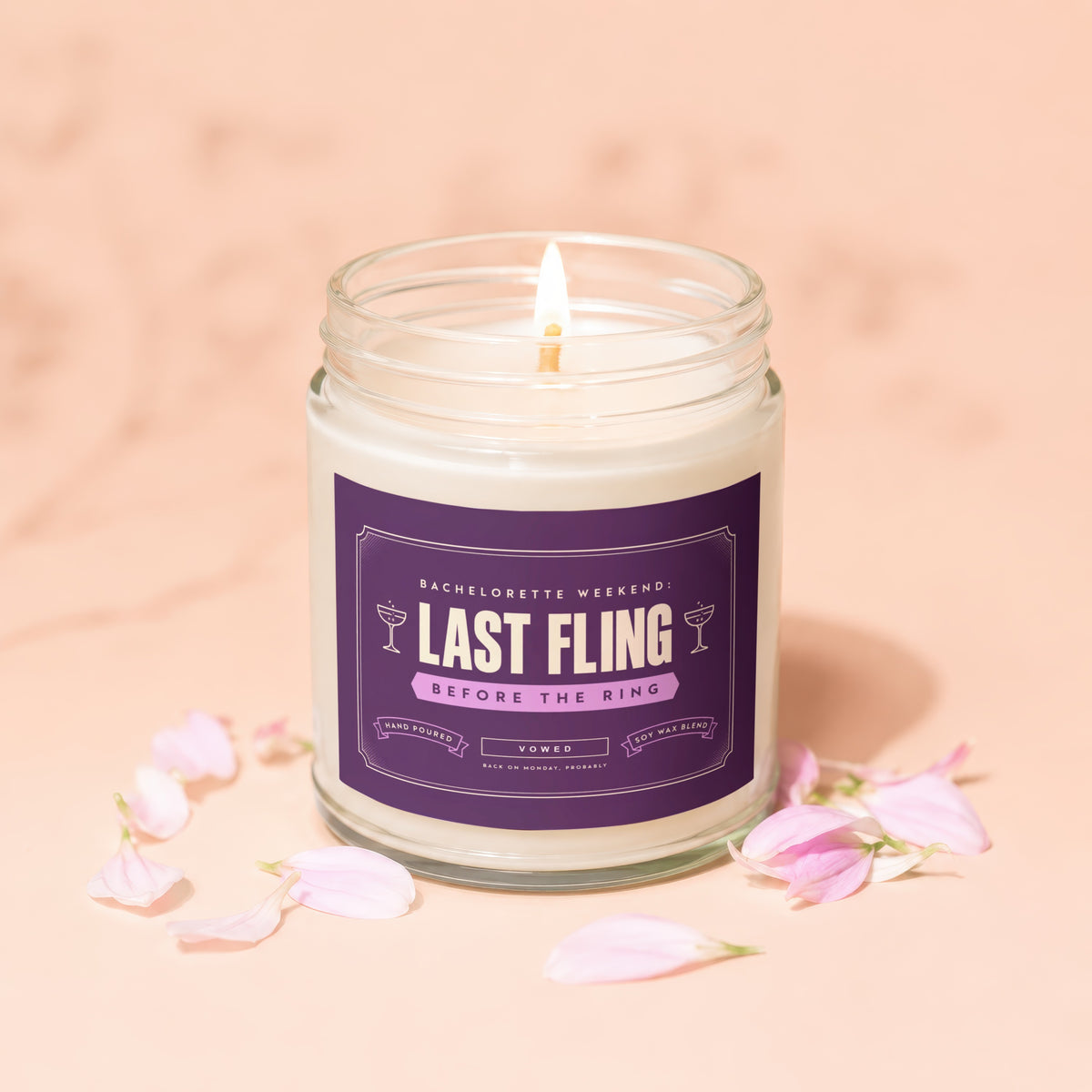 Candle with label "Last Fling Before The Ring" surrounded by pink petals.