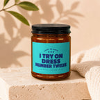 Candle with teal label that reads "I TRY ON DRESS NUMBER TWELVE".