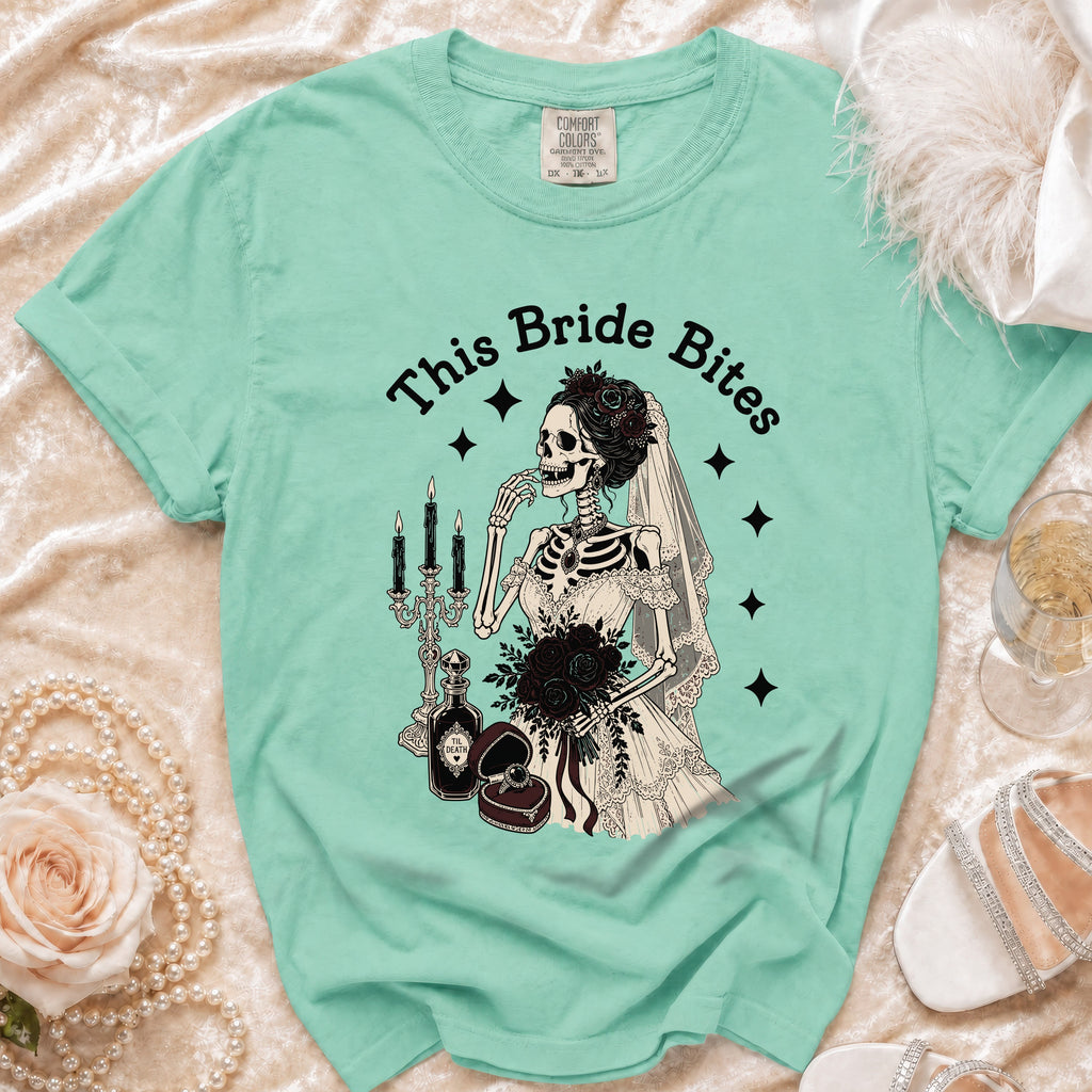 T-shirt with "This Bride Bites" text and a skeleton bride with black roses and wedding items.
