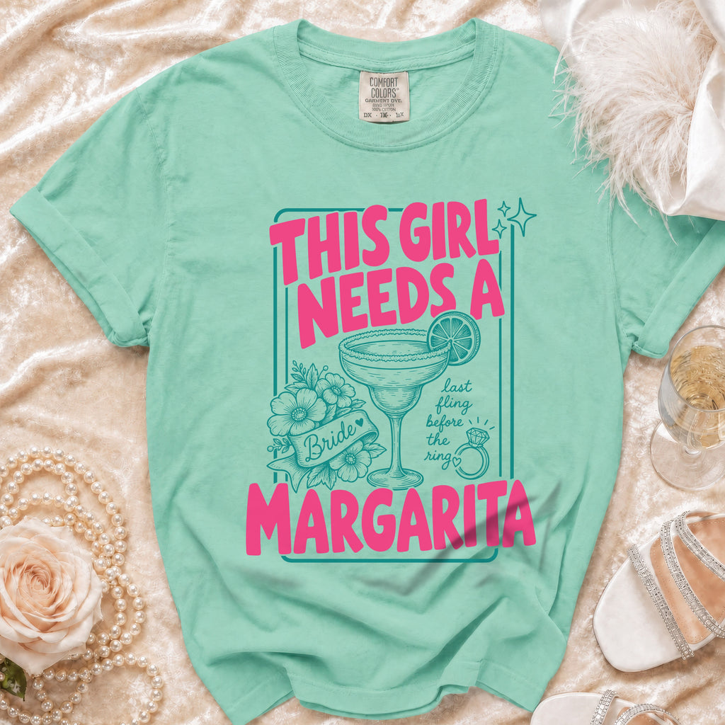 Aqua t-shirt with pink text reading "This girl needs a margarita" and bride imagery.