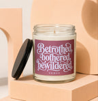 Candle with label "Betrothed, bothered, bewildered VOWED" on a peach pedestal.