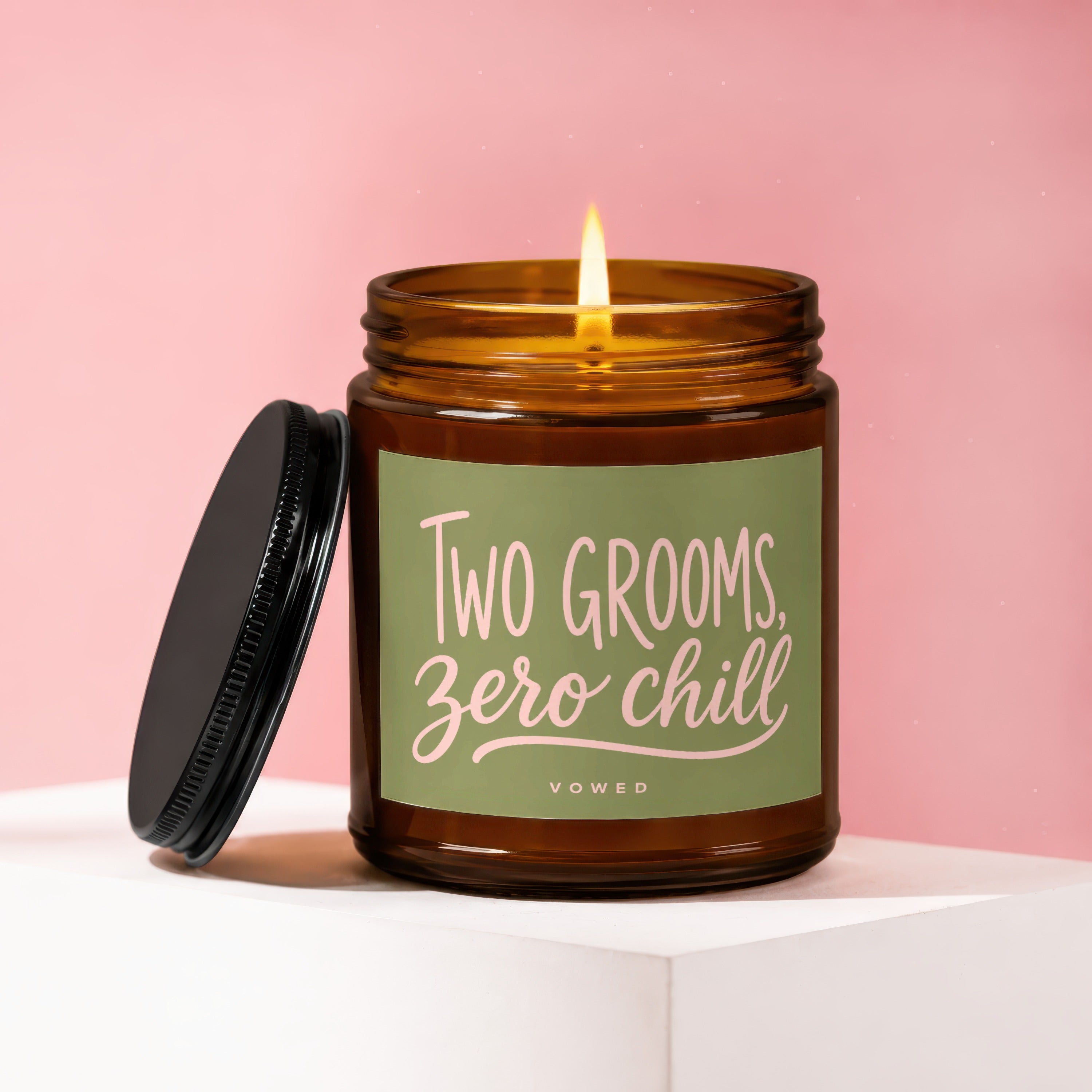 Amber jar candle with a lit wick and "TWO GROOMS, zero chill" text.