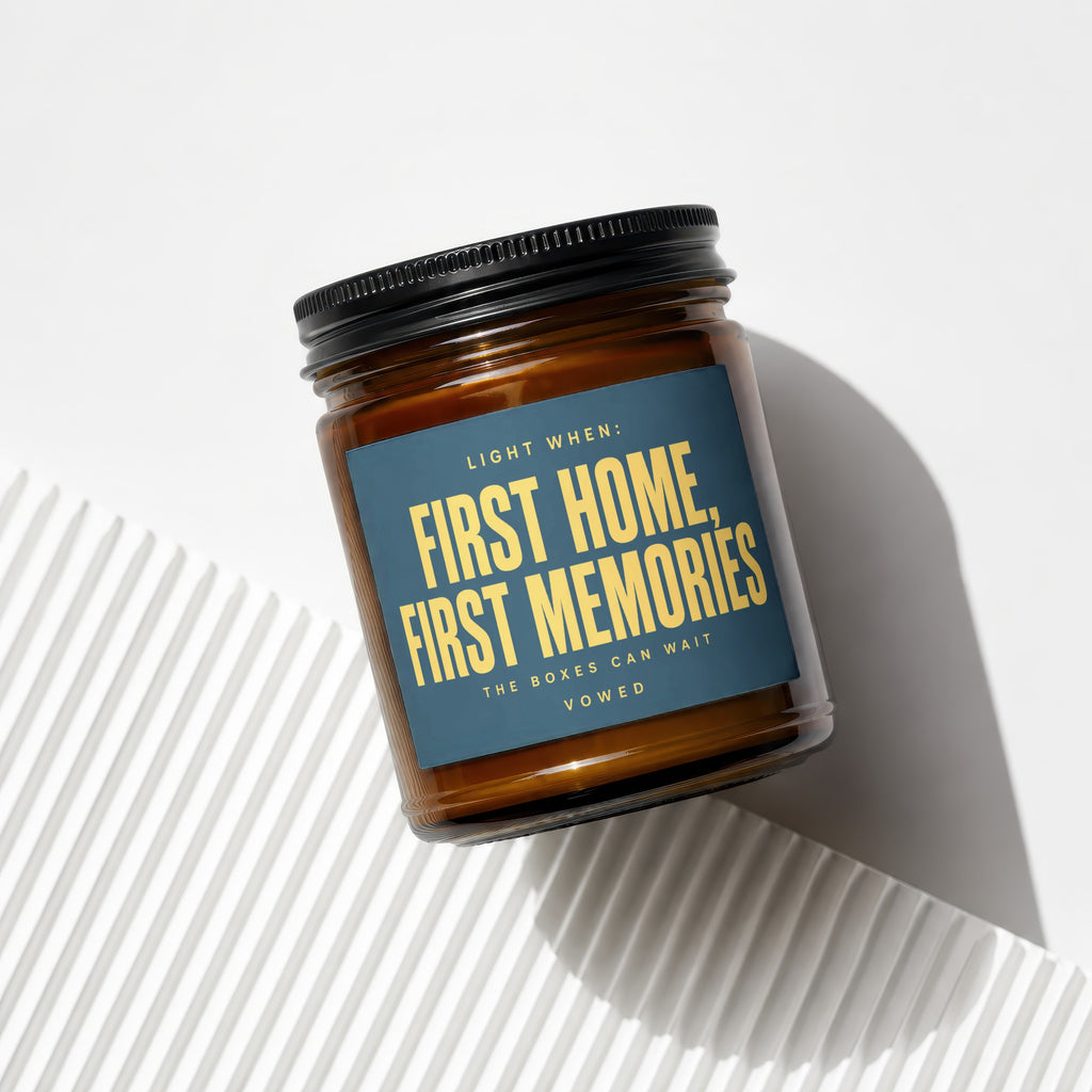 Amber glass candle with dark blue label that reads "First Home, First Memories."