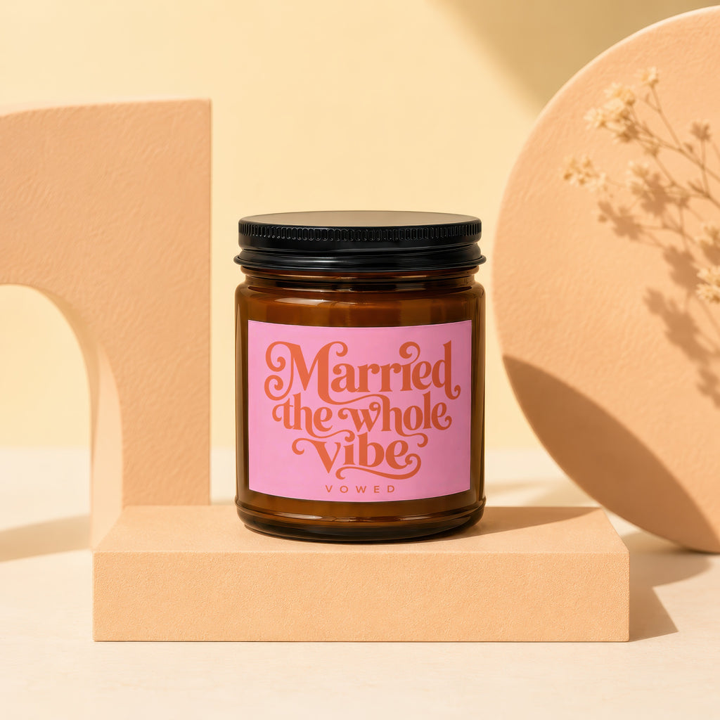Brown glass candle with pink label reading "Married the Whole Vibe" and "VOWED".