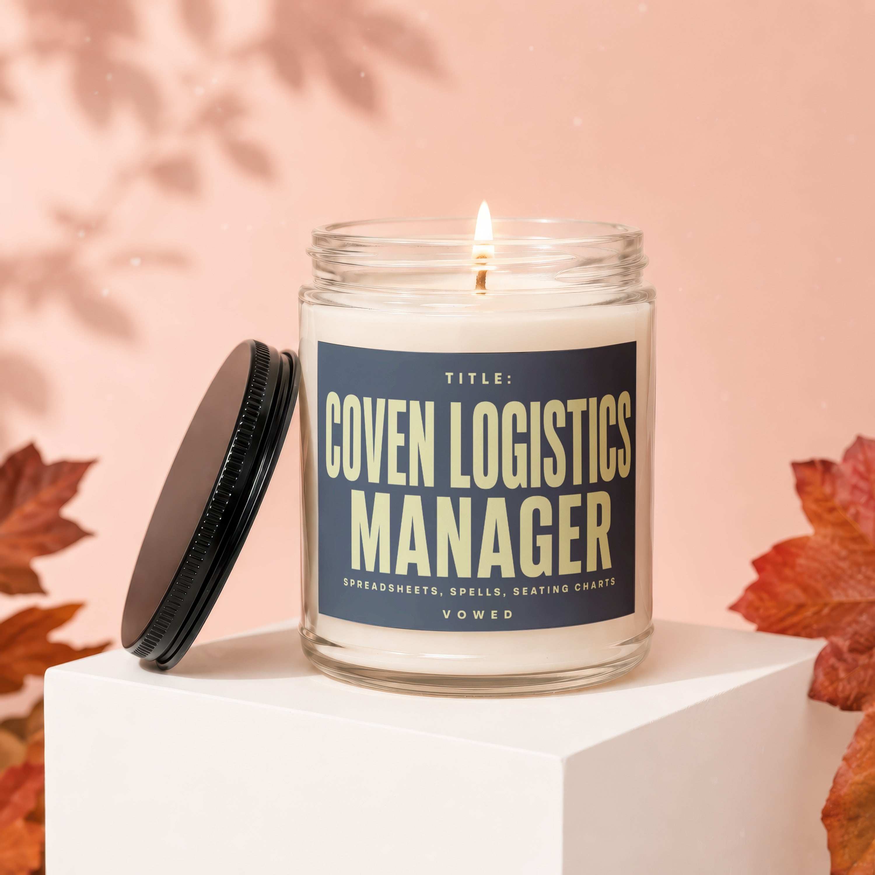 Candle labeled "Coven Logistics Manager - Spreadsheets, Spells, Seating Charts"
