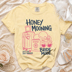 Yellow t-shirt with "Honey Mooning Bride Mode" text and travel graphics.