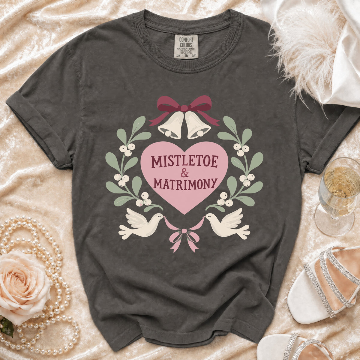 Grey t-shirt with "Mistletoe & Matrimony" text, bells, and doves graphic.