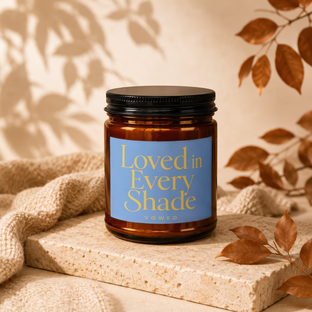 Brown candle with a blue label that reads "Loved in Every Shade"