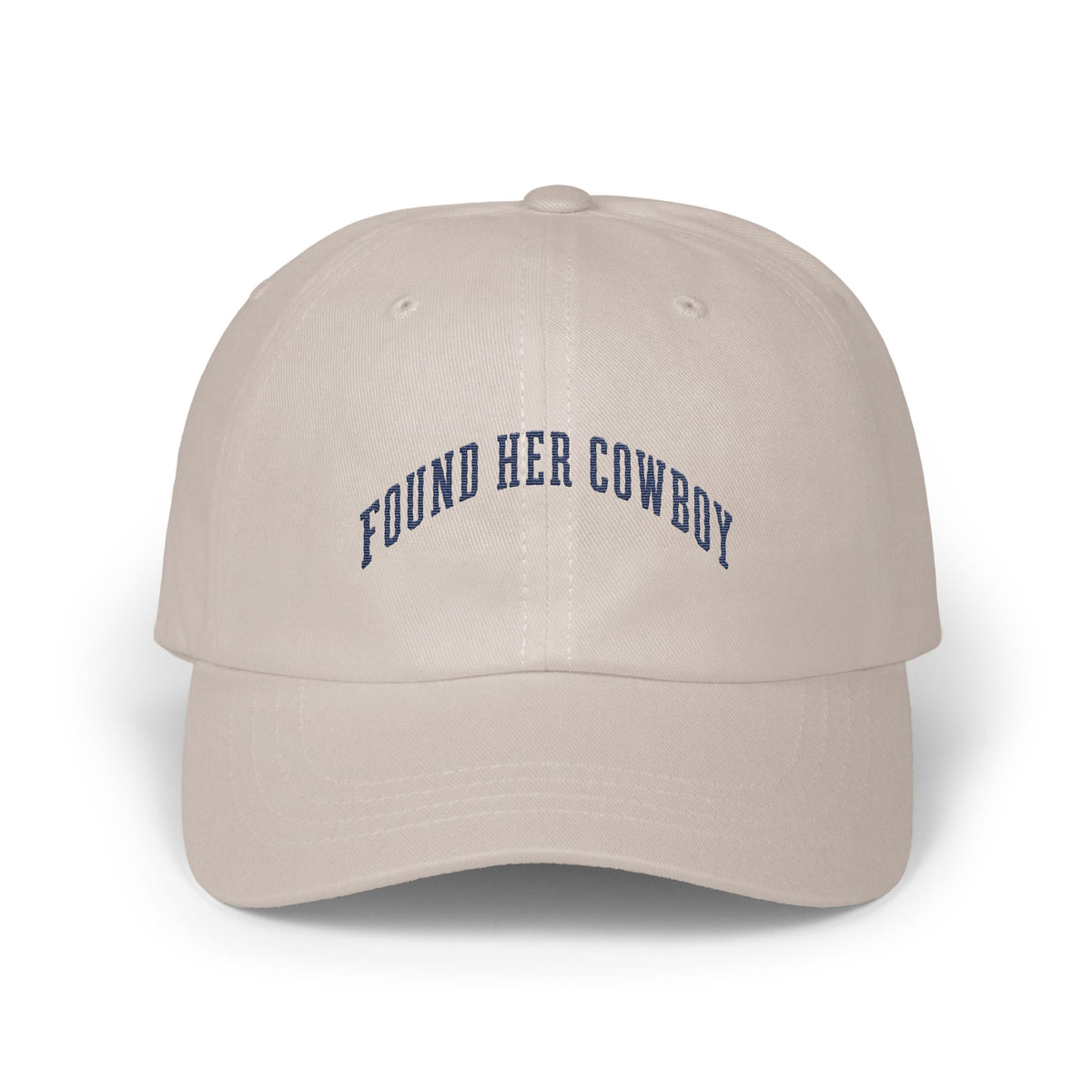 Beige baseball cap with curved dark blue embroidered text reading FOUND HER COWBOY centered on the front panels.