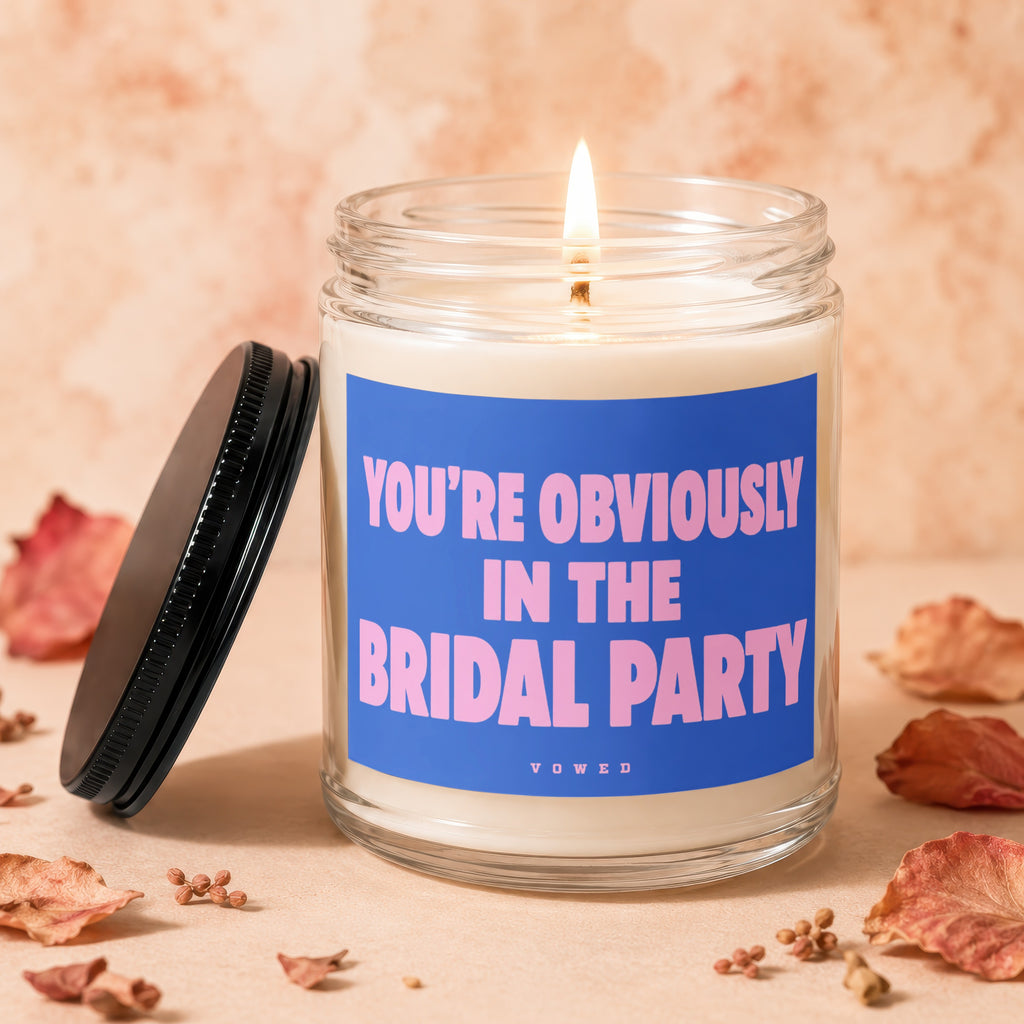 Candle burning in glass jar with blue label reading: "YOU'RE OBVIOUSLY IN THE BRIDAL PARTY".