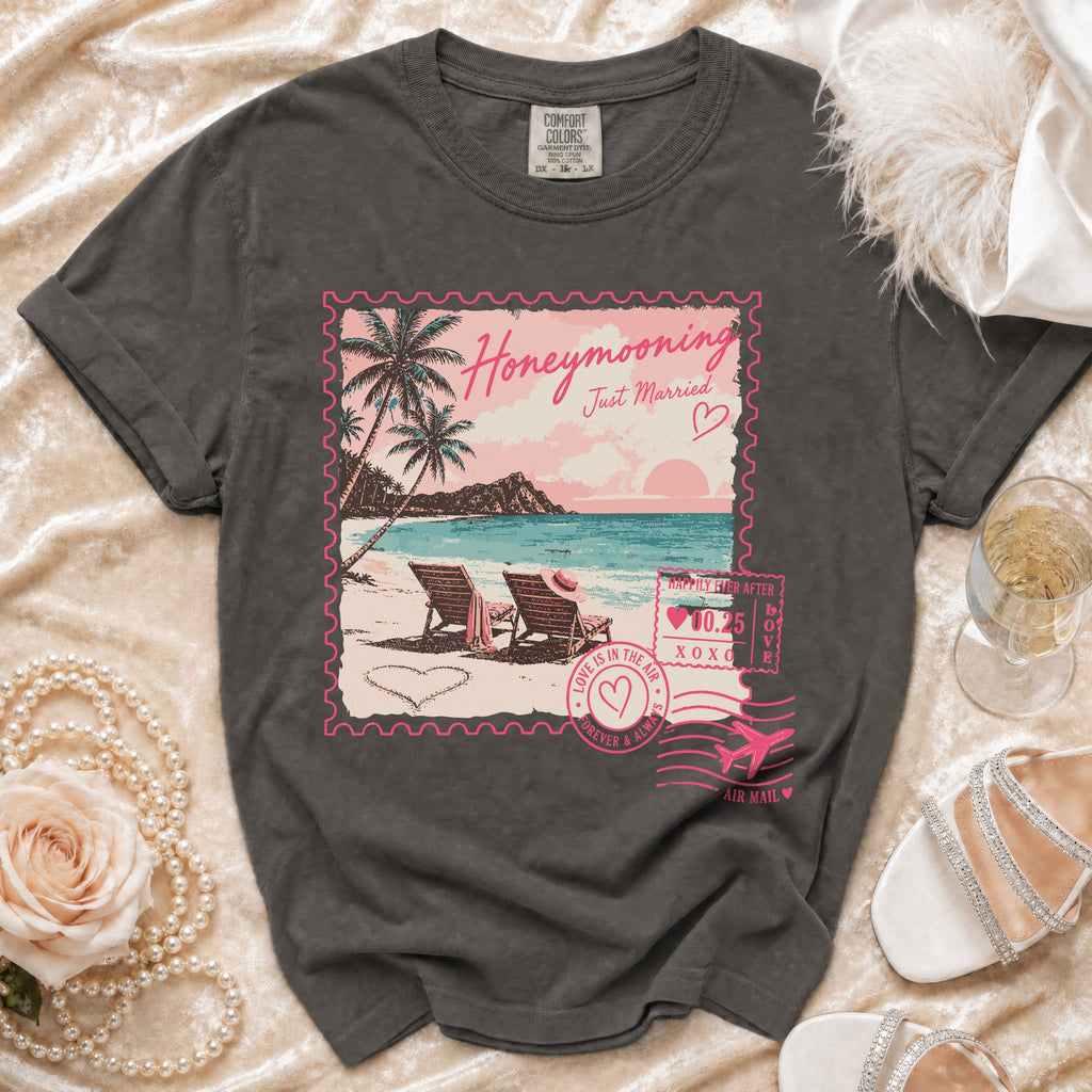 T-shirt with "Honeymooning Just Married" beach scene stamp graphic.