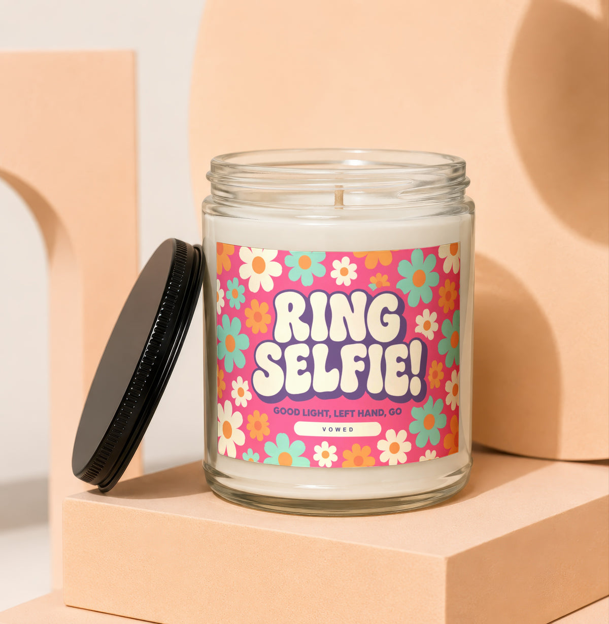 Candle with "RING SELFIE! GOOD LIGHT, LEFT HAND, GO VOWED" text and floral pattern.