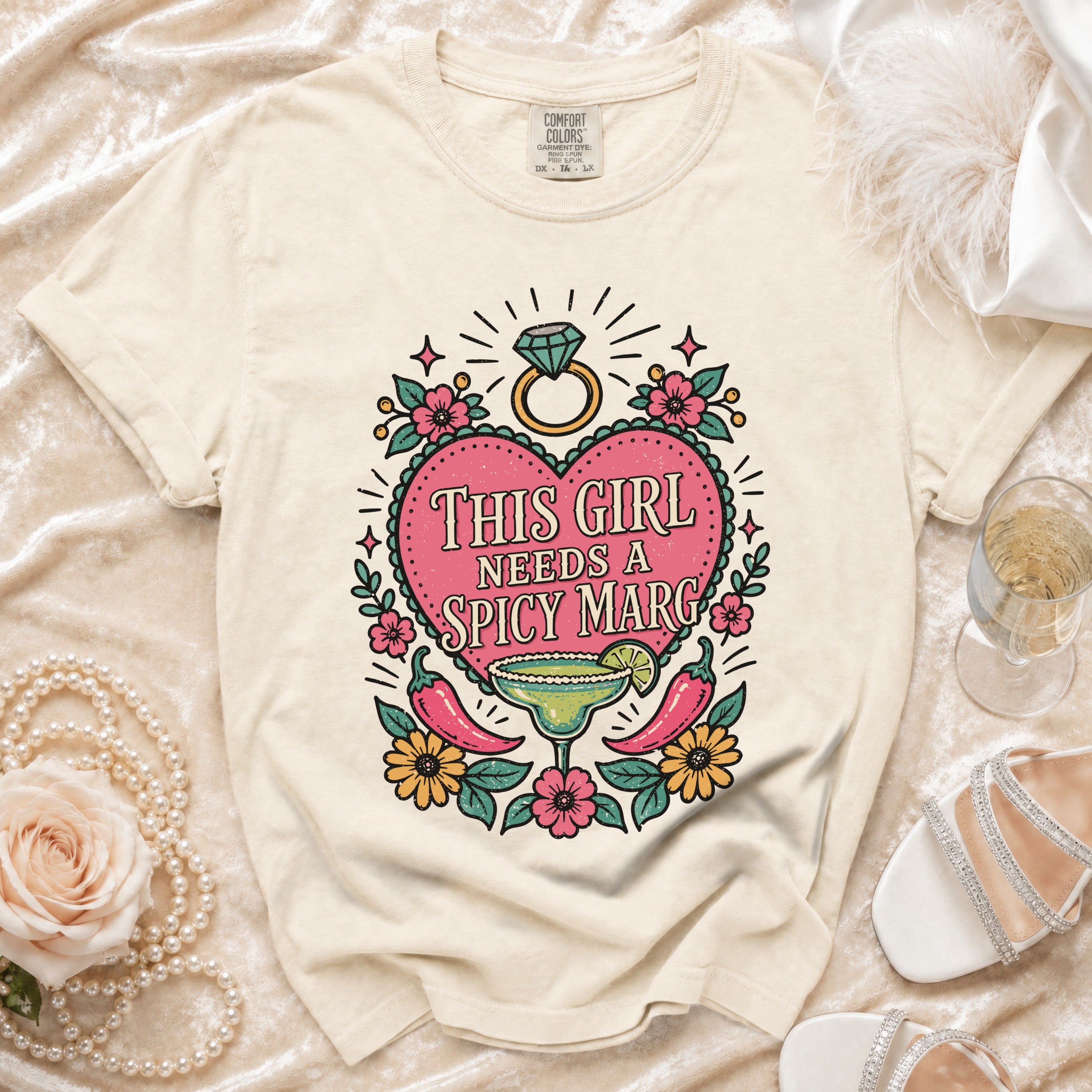Cream t-shirt with "This Girl Needs a Spicy Marg" graphic, featuring a margarita and chili peppers.