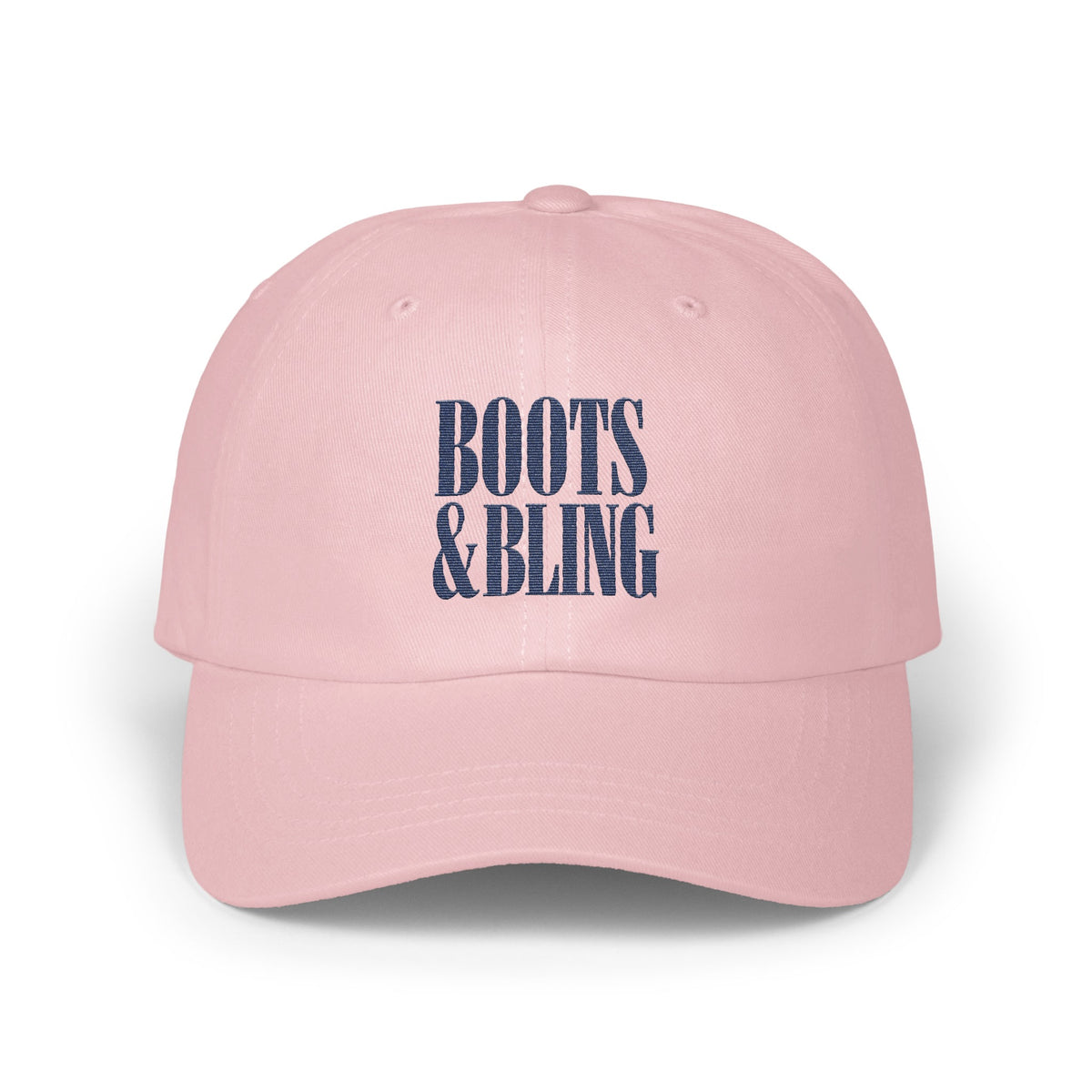 A light pink baseball cap features embroidered blue text reading BOOTS AND BLING centered on the front.