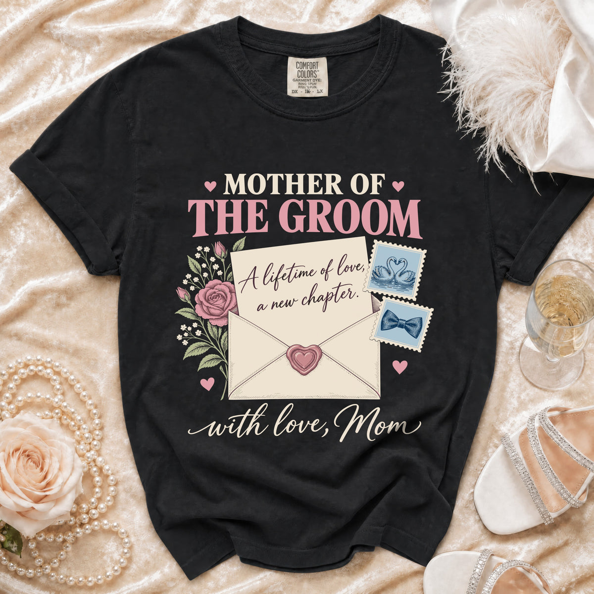 Black t-shirt with "Mother of the Groom" text and floral envelope design.