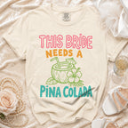 Cream t-shirt with "This Bride Needs a Piña Colada" text and graphic.