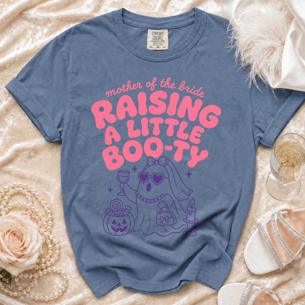 Blue Comfort Colors shirt with "mother of the bride raising a little boo-ty" text.