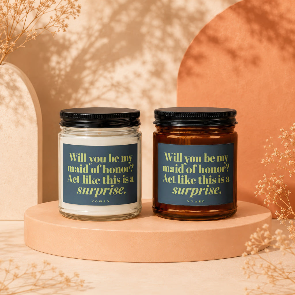Two candles with labels reading "Will you be my maid of honor? Act like this is a surprise."