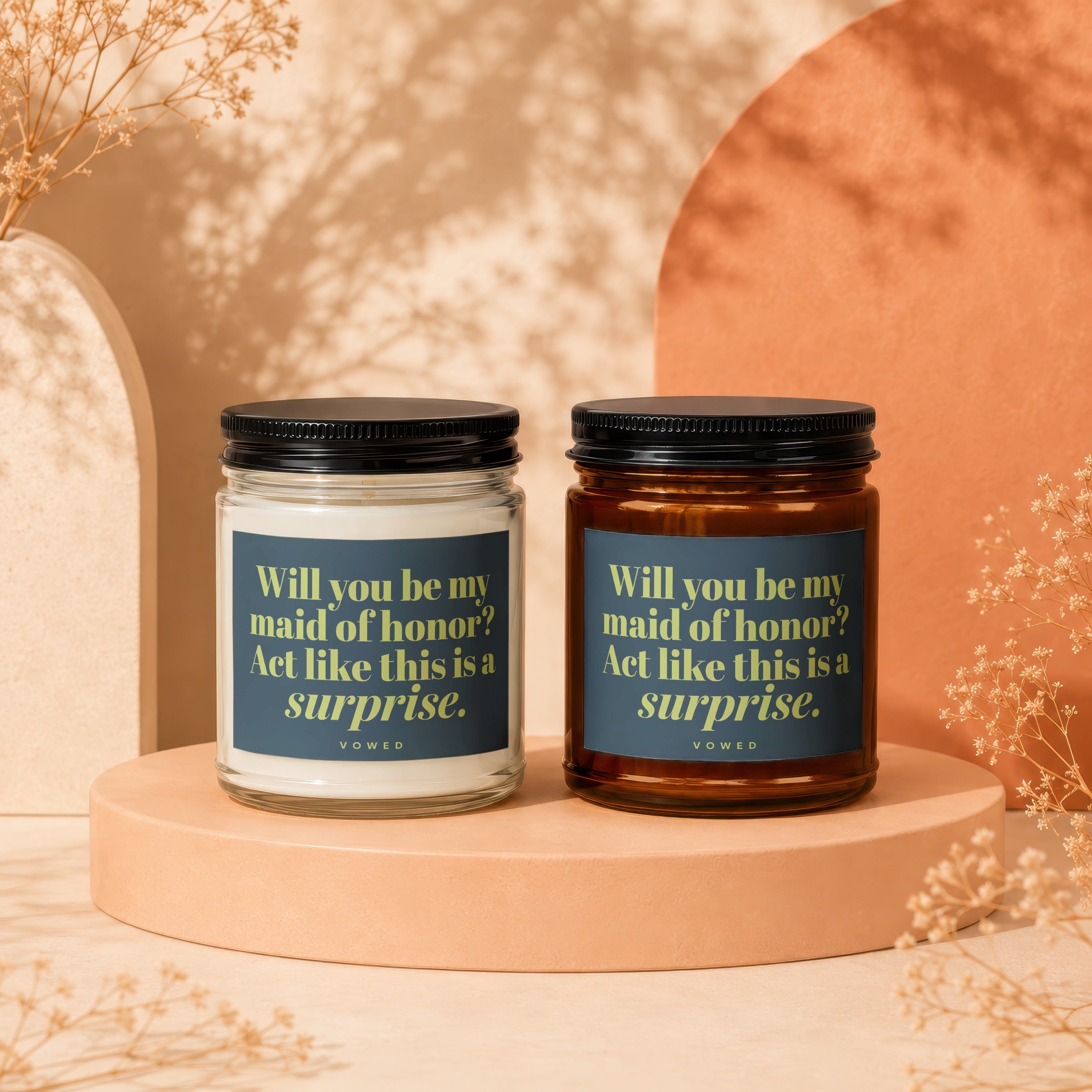 Two candles with labels reading "Will you be my maid of honor? Act like this is a surprise."