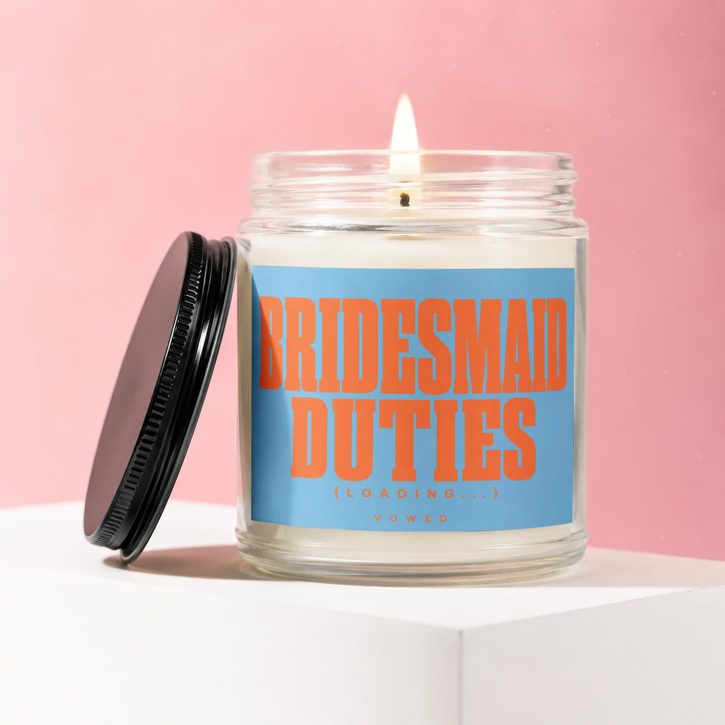 Candle with "Bridesmaid Duties (Loading...) Vowed" text on a blue label.