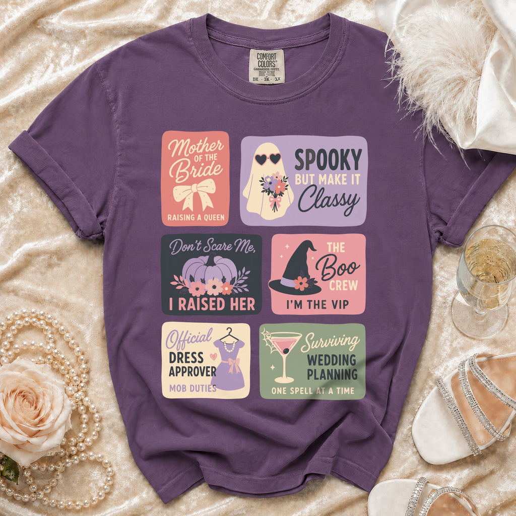 Purple t-shirt with graphic squares: Mother of the Bride, Spooky but make it Classy, Don't Scare Me, I Raised Her, The Boo Crew, Official Dress Approver, Surviving Wedding Planning.