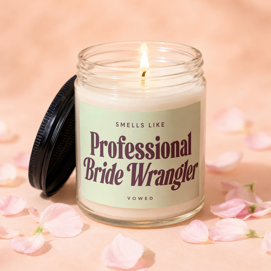 Jar candle with lit flame reading "Smells Like Professional Bride Wrangler"