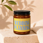 Amber jar candle with yellow label reading "Smells Like Wedding Planning Vowed."