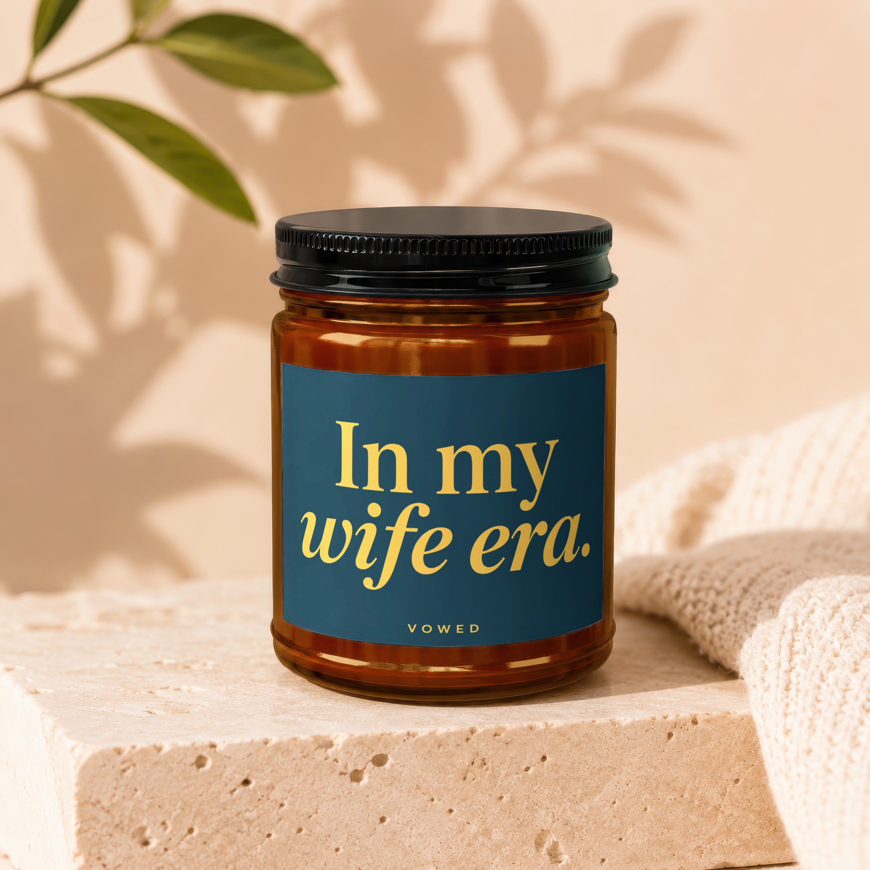 Amber glass candle with blue label reading "In my wife era. VOWED".