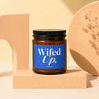 Brown glass candle with blue label reading "Wifed Up. VOWED".