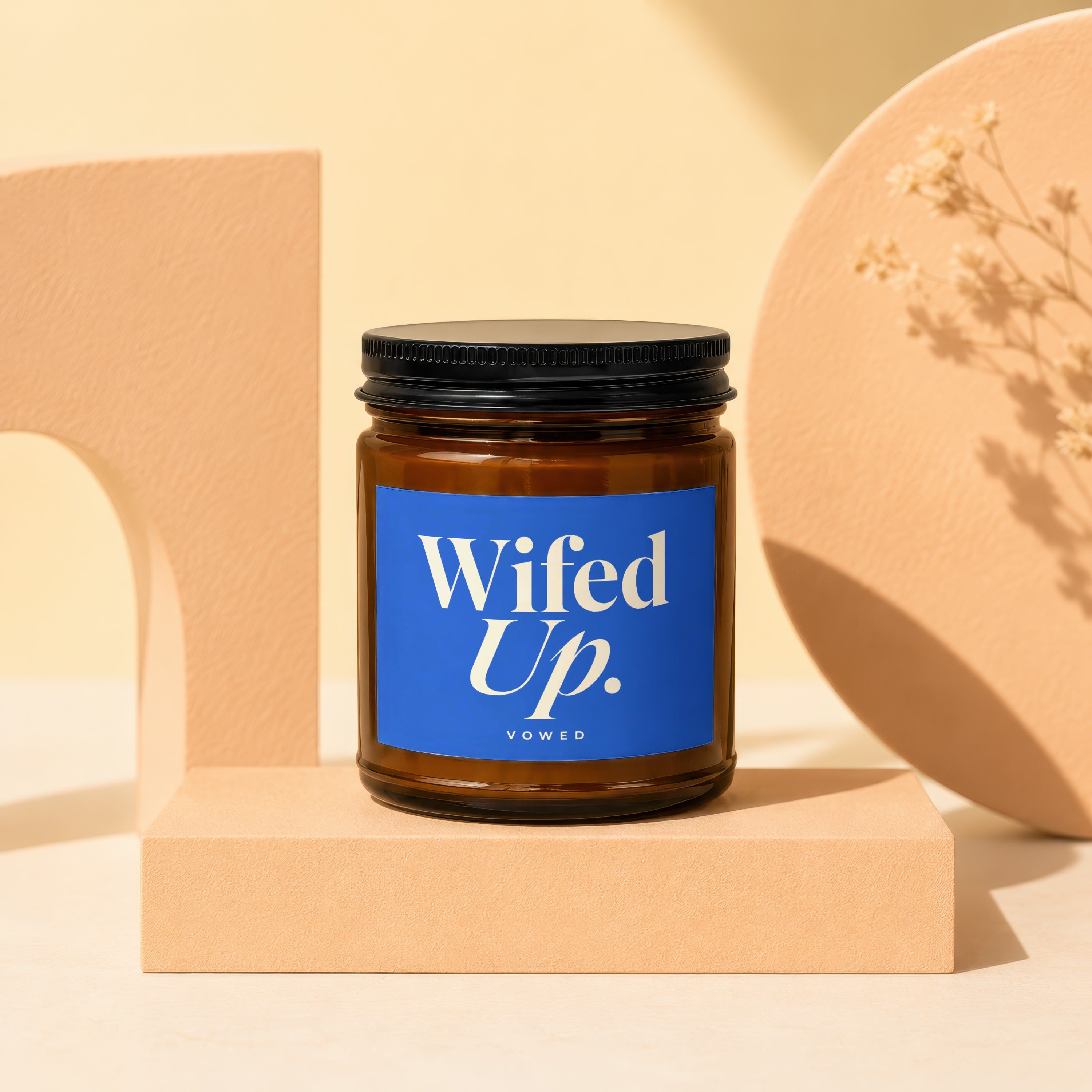 Brown glass candle with blue label reading "Wifed Up. VOWED".