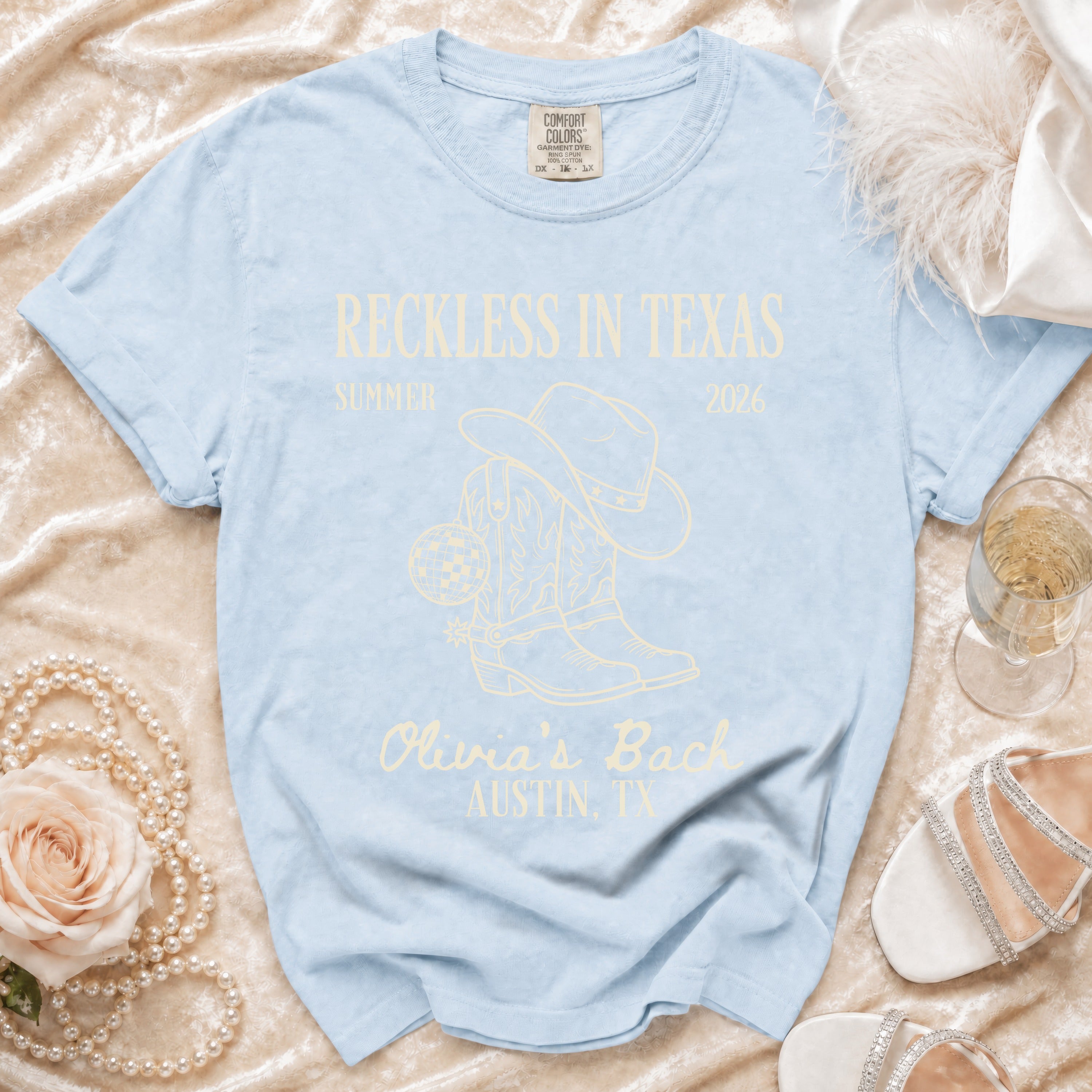 Light blue t-shirt with "Reckless in Texas 2026 Olivia's Bach Austin, TX" text.