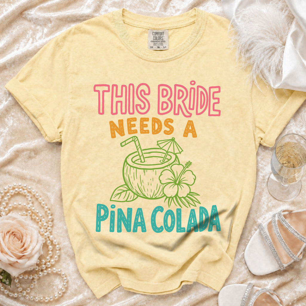 Yellow t-shirt with "THIS BRIDE NEEDS A PINA COLADA" graphic and coconut illustration.