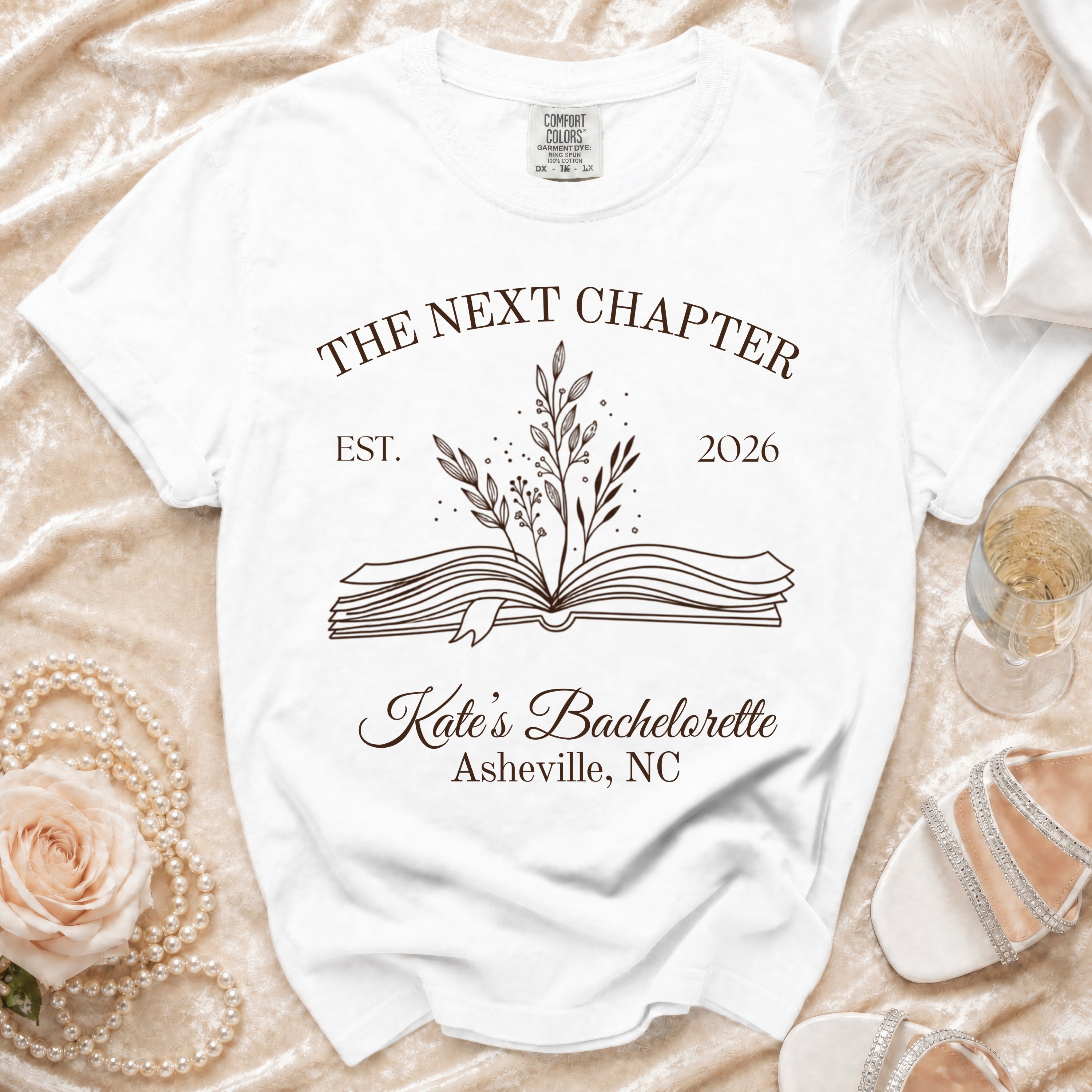 White t-shirt with "The Next Chapter Est. 2026 Kate's Bachelorette Asheville, NC".