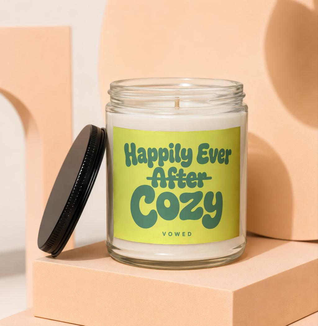 Glass candle with "Happily Ever After Cozy" text on a light green label.