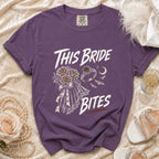 Purple t-shirt with "This Bride Bites" text and gothic bridal graphics.