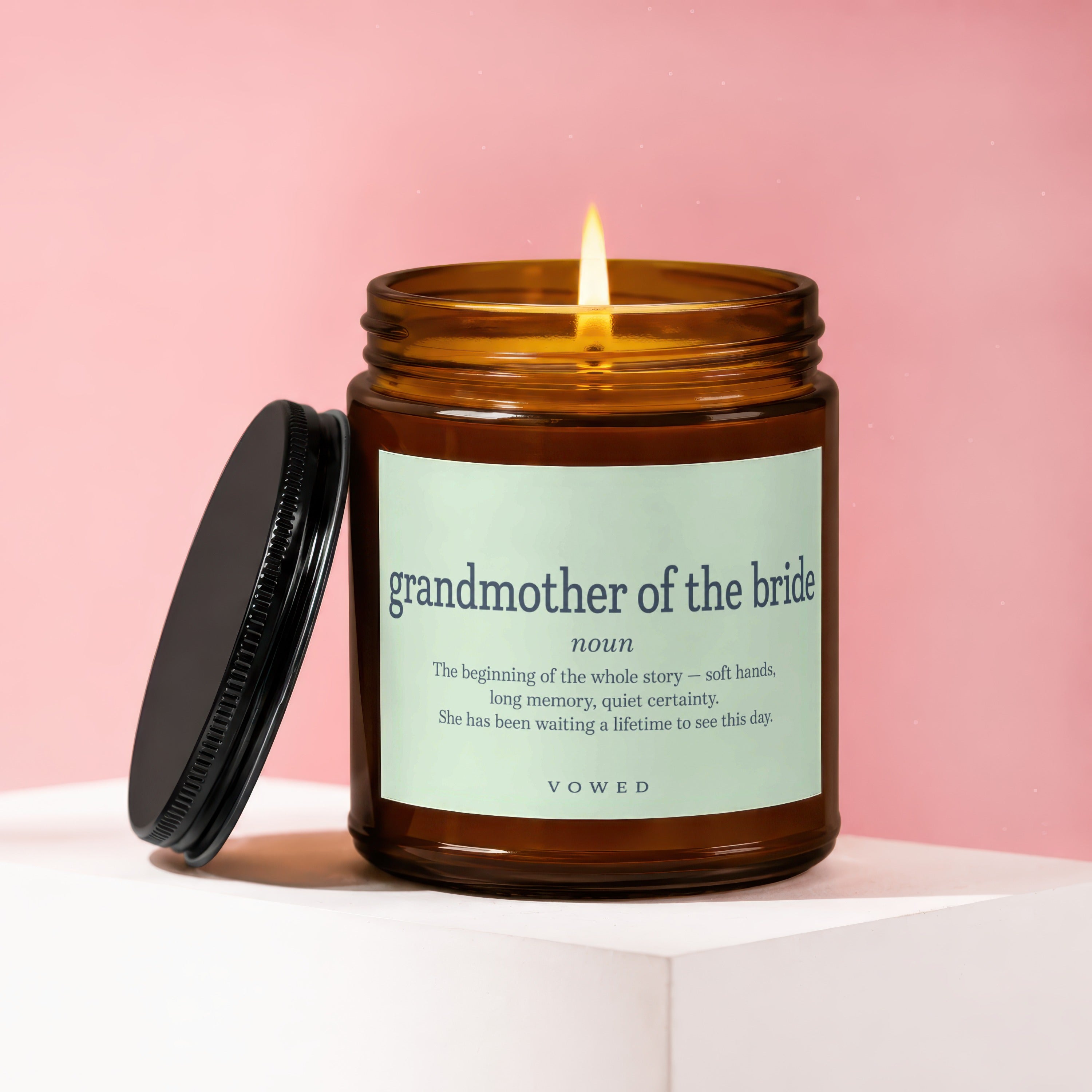 Candle with lit flame, brown glass, and a "grandmother of the bride" definition label.