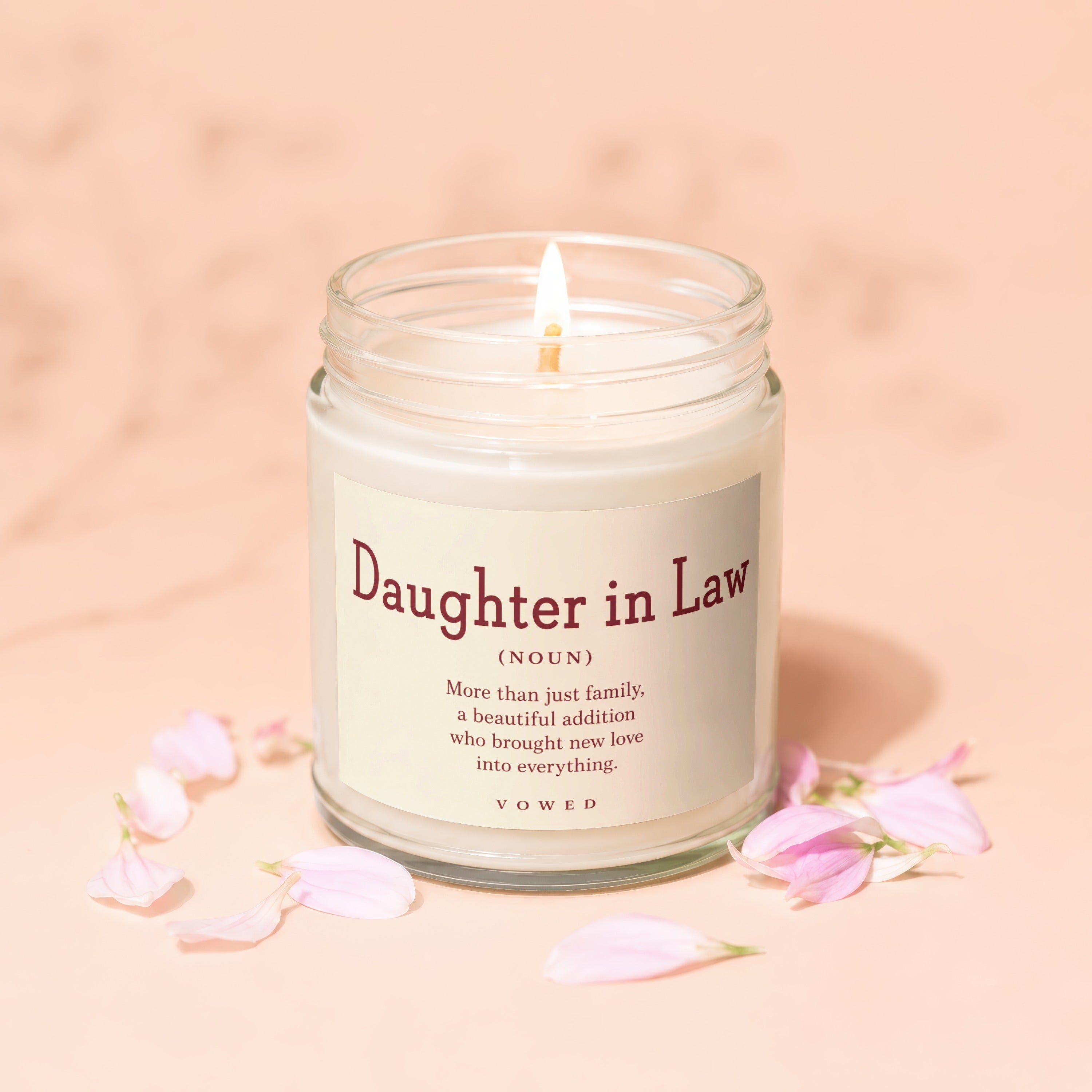 Glass jar candle labeled "Daughter in Law" with definition and flower petals.