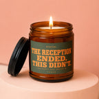Amber candle with lit wick, reads "STATUS: THE RECEPTION ENDED. THIS DIDN'T. THE PARTY JUST MOVED IN VOWED"