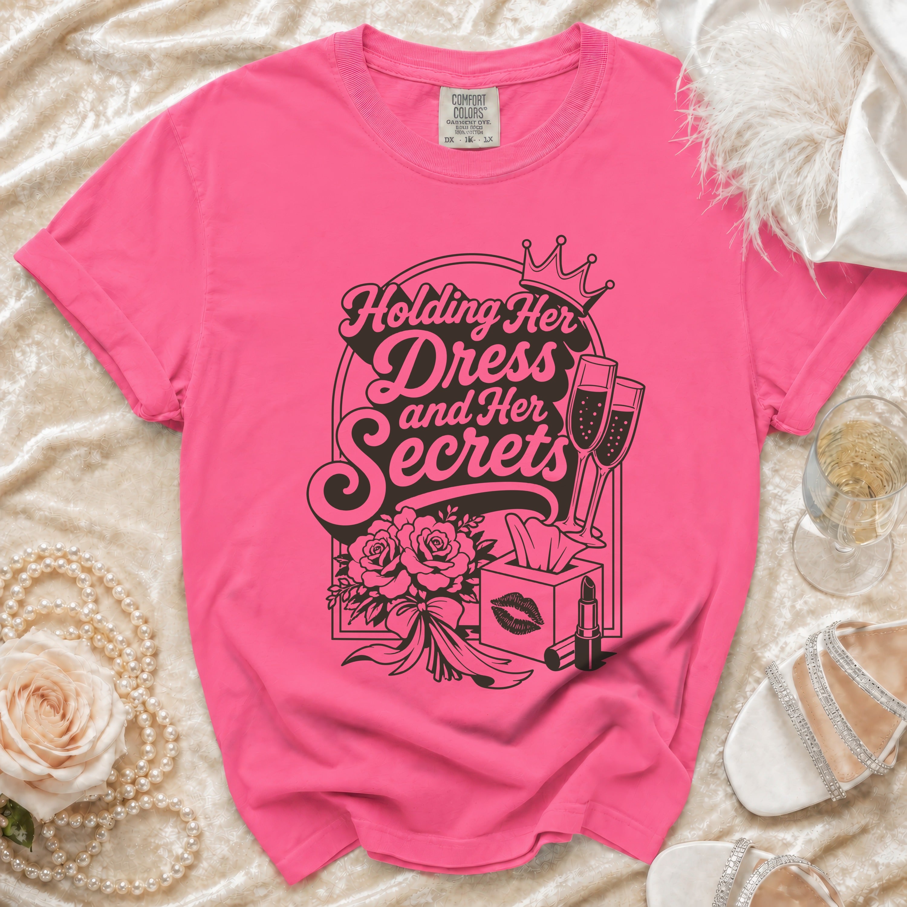 Pink Comfort Colors t-shirt with "Holding Her Dress and Her Secrets" graphic.