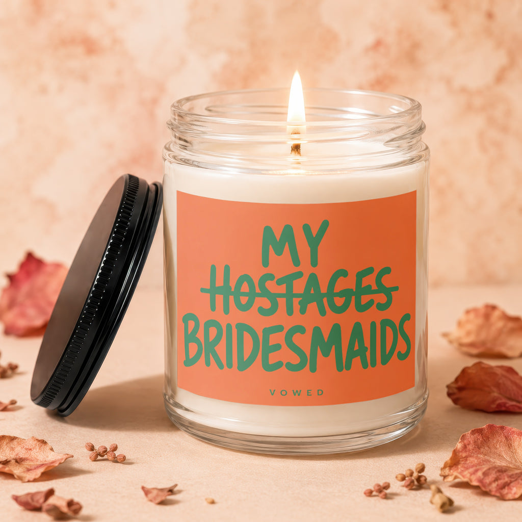 Candle with "My Hostages Bridesmaids VOWED" text on an orange label.