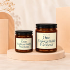 Two amber glass candles with black lids and cream labels.
