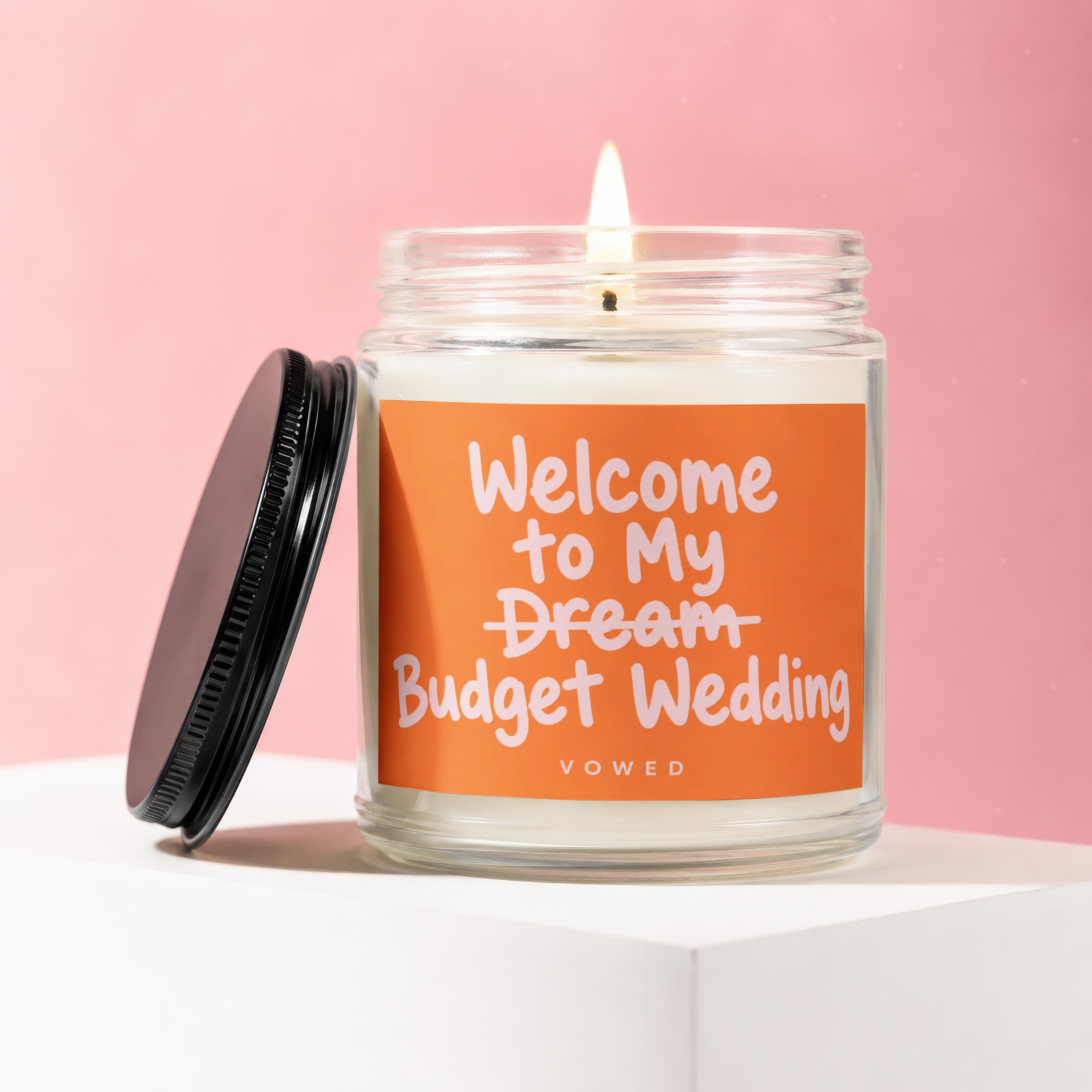 Candle with label "Welcome to My Budget Wedding" on a pink background.