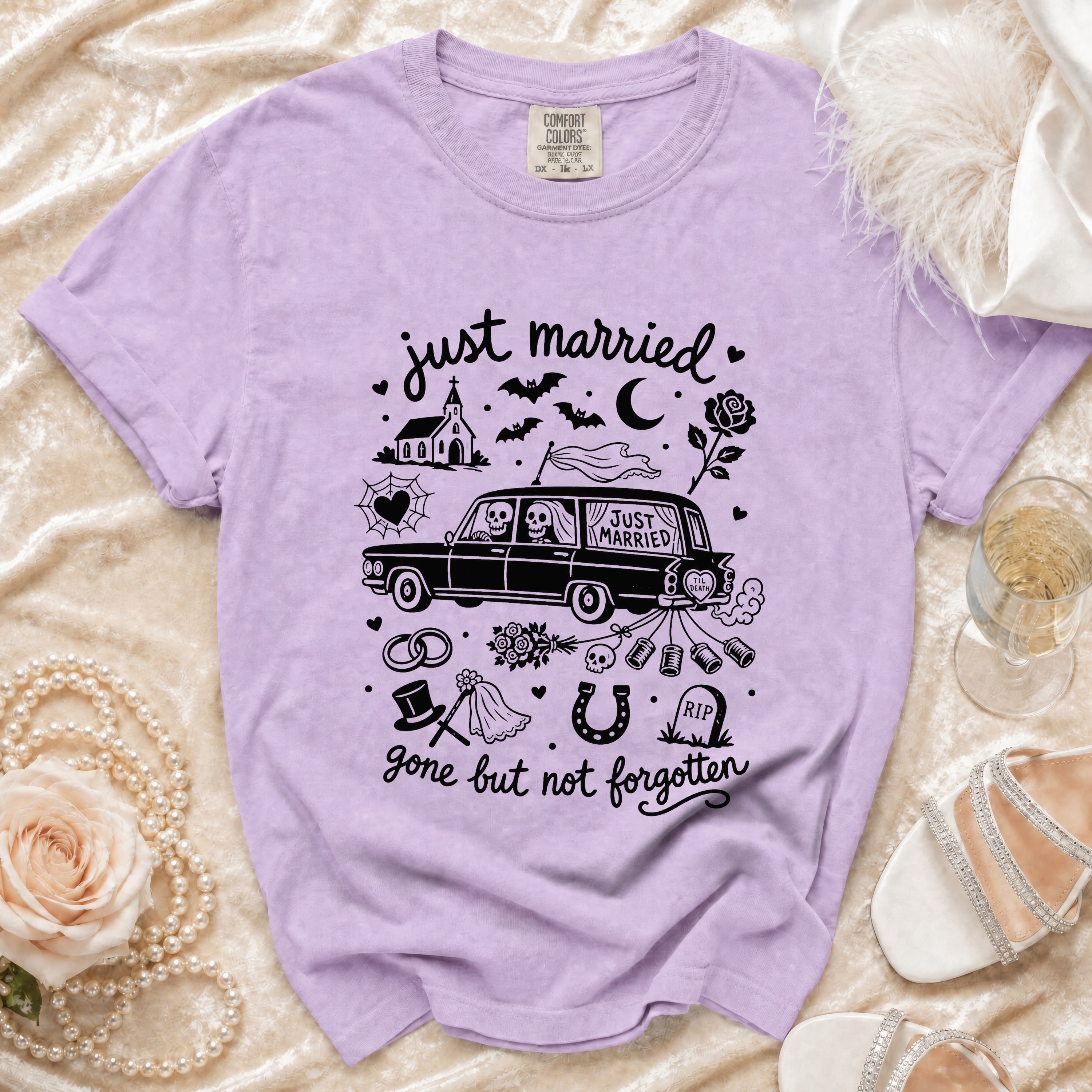 Purple t-shirt with "just married" text, skeleton couple in a car, and wedding/gothic elements.