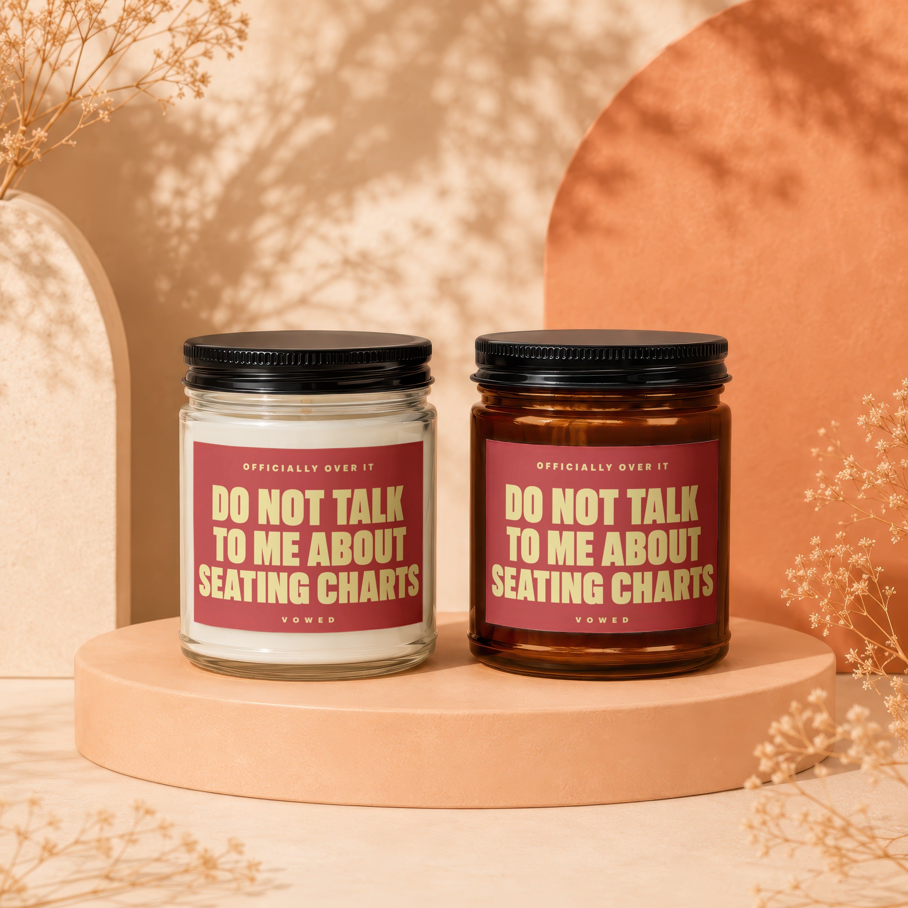 Two candles, one clear and one amber, with red labels reading "DO NOT TALK TO ME ABOUT SEATING CHARTS."