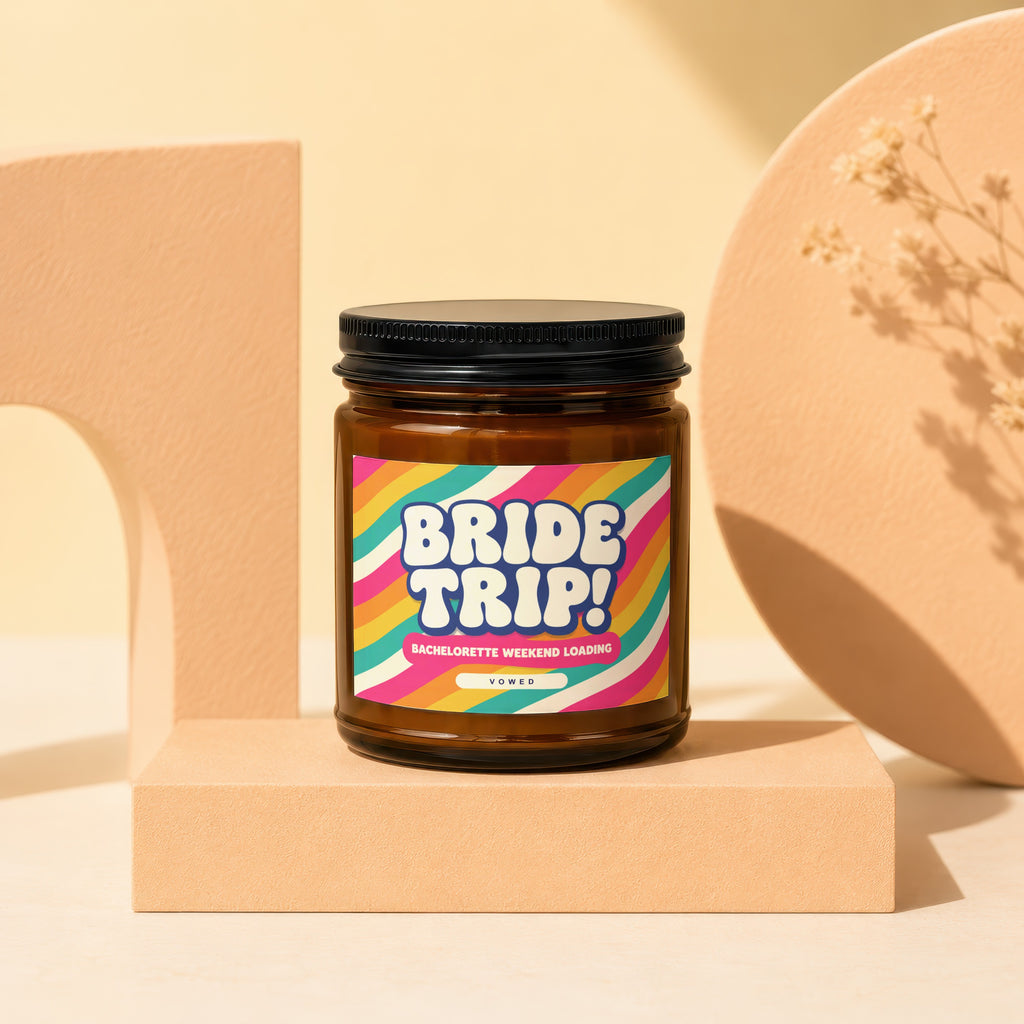 Amber glass candle with "BRIDE TRIP! BACHELORETTE WEEKEND LOADING" text on a colorful label.