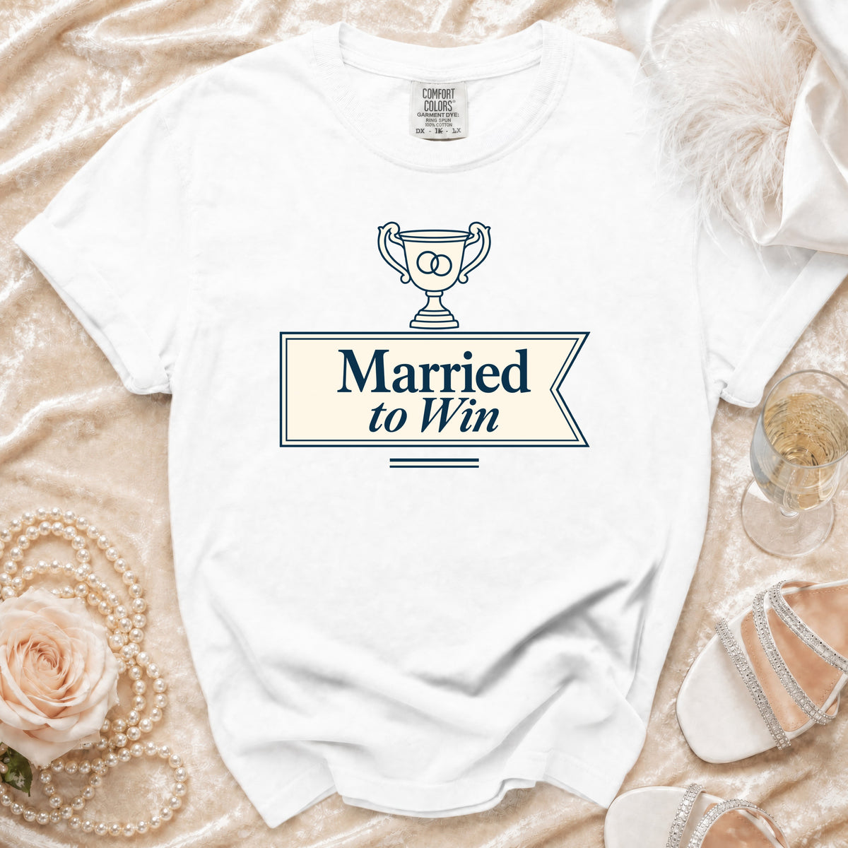 White t-shirt with "Married to Win" text and wedding rings in a trophy.