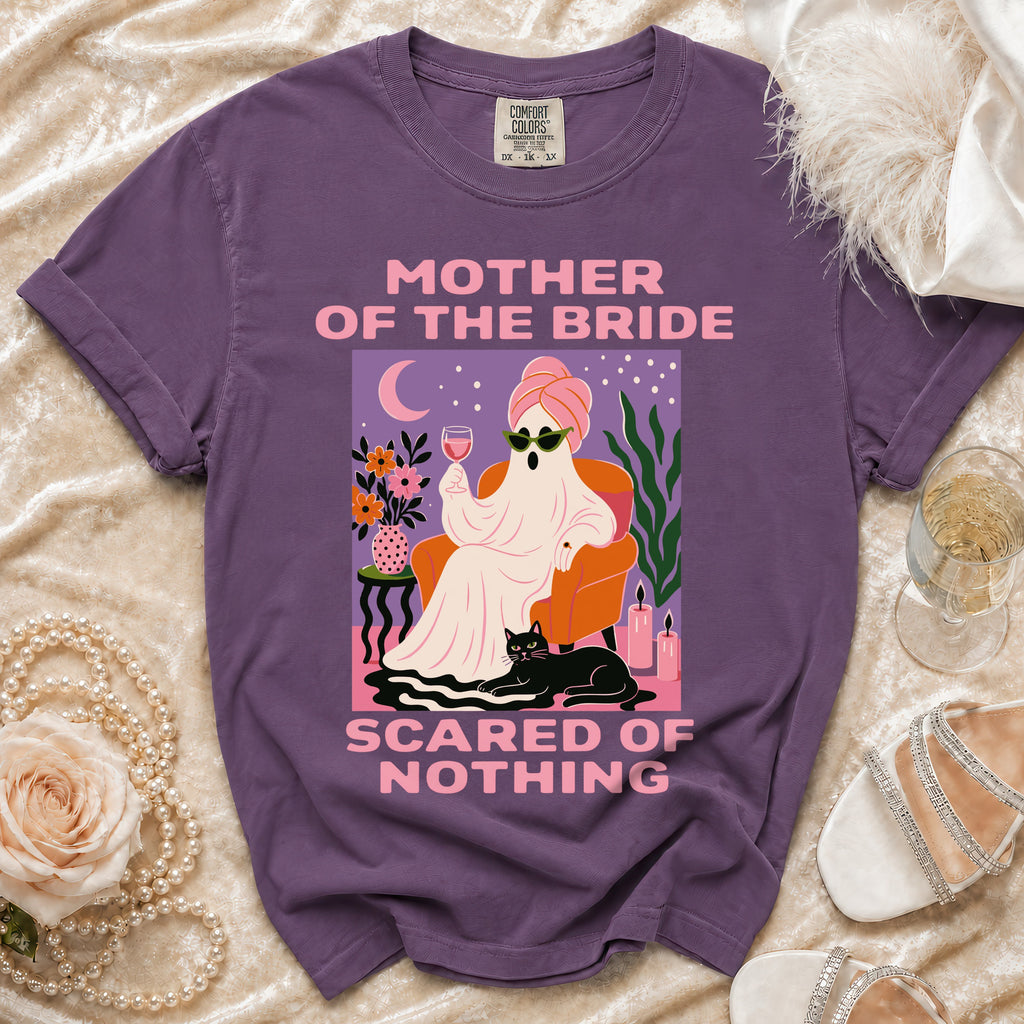 Purple Comfort Colors t-shirt with "Mother of the Bride Scared of Nothing" graphic.