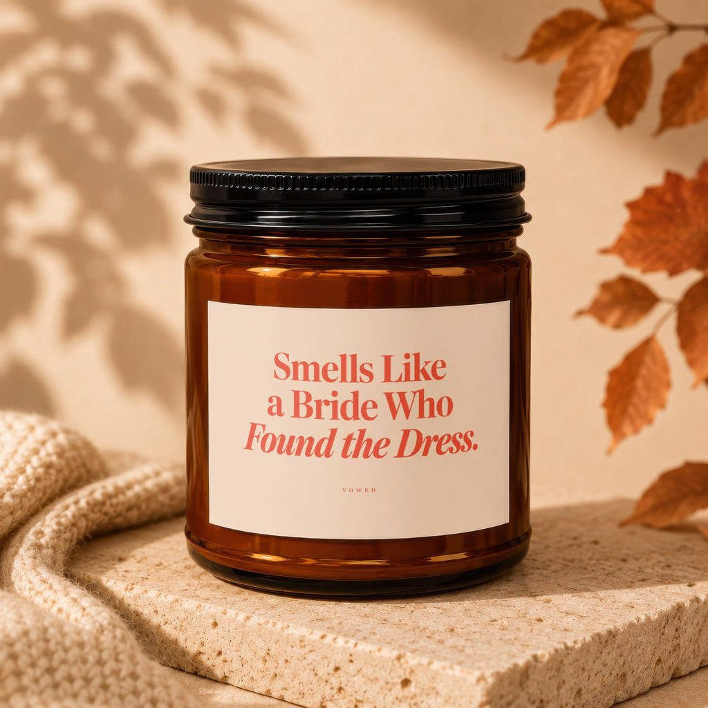 Amber candle with black lid labeled "Smells Like a Bride Who Found the Dress."