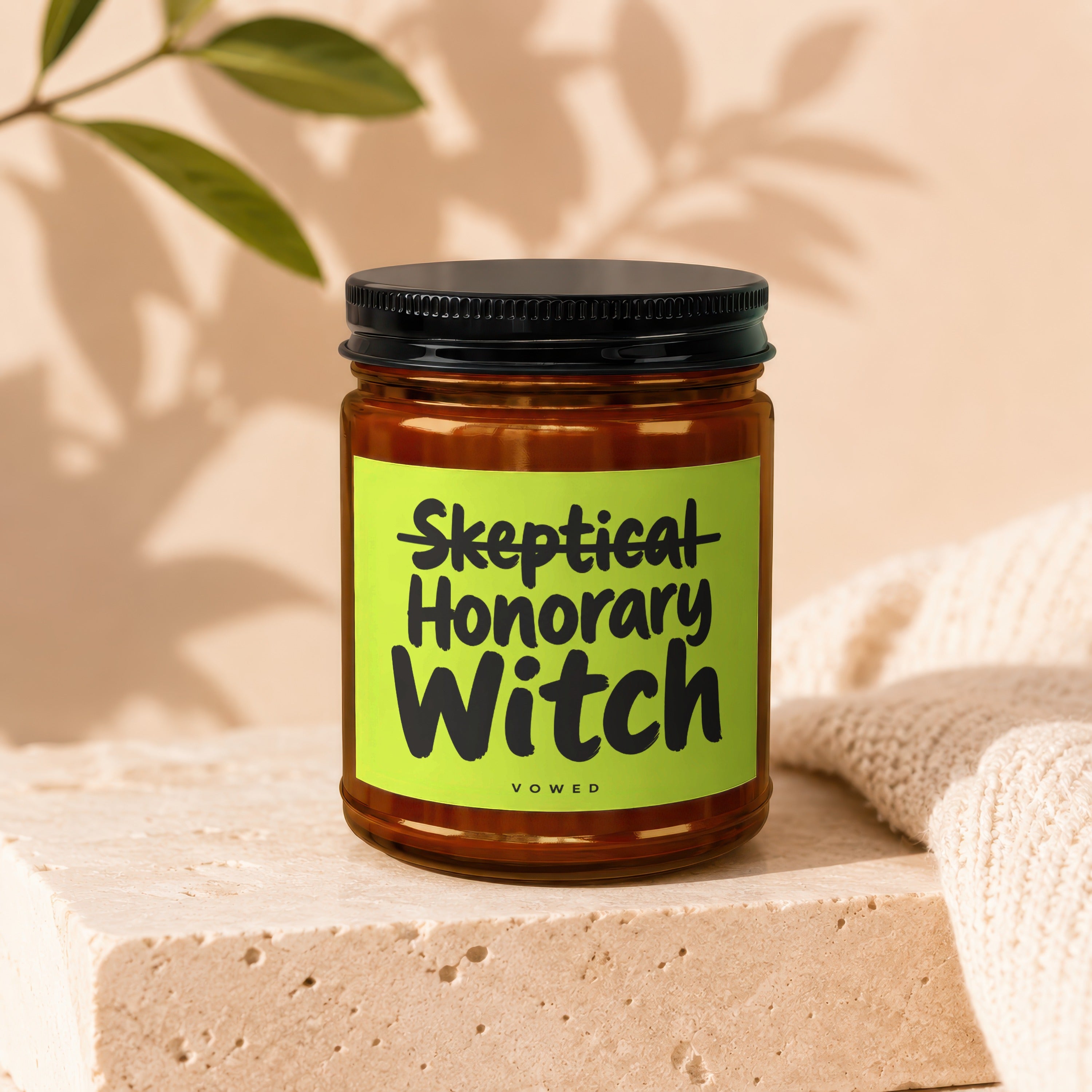 Glass candle with black lid labeled "Skeptical Honorary Witch Vowed".